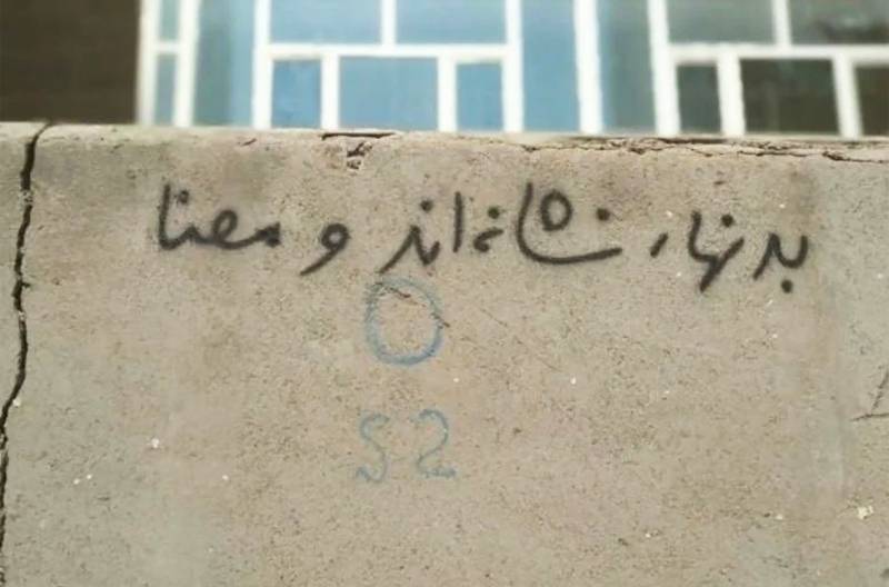 Graffiti on a wall says, ‘Bodies are signs and meanings’, Iran