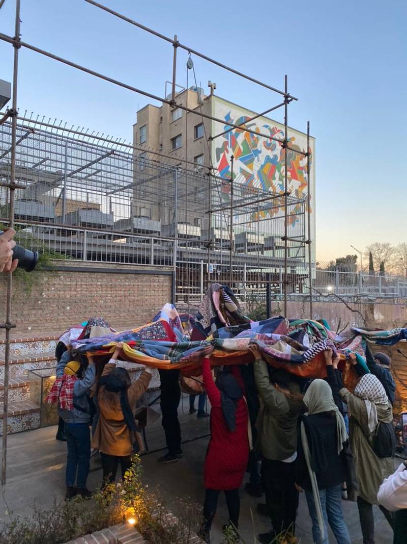 The large coat that had been created from all of the pieces of fabric was moved outside through the location’s window, and from there it was meant to be hung atop a large hanger that was previously built by the audience. ‘An Equivalence of Our Distance' workshop, 2021.